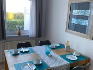 a dining room table with blue placemats on it at Am Seeufer 59a Fewo 9 in Waren