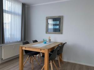 a dining room with a wooden table and chairs at Am Seeufer 59a Fewo 9 in Waren