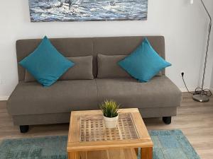 a couch with two blue pillows and a coffee table at Am Seeufer 59a Fewo 9 in Waren +15 photos
