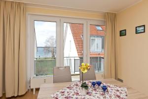 a room with a table with flowers and a large window at Am Seeufer 60 Fewo 605 in Waren