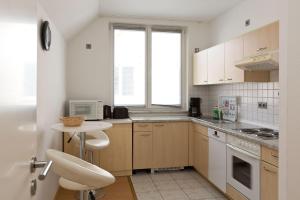 a kitchen with white cabinets and a table with a microwave at Am Seeufer 60 Fewo 605 in Waren