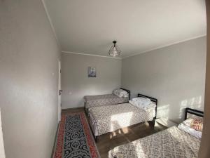 a bedroom with two beds and a rug at Амир гостевой дом в Корумду in Korumdy +6 photos