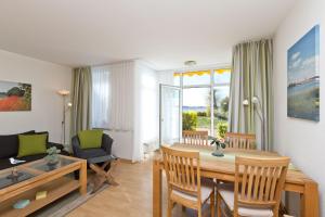a living room with a dining table and a living room with a couch at Am Seeufer 59b Fewo 3 in Waren