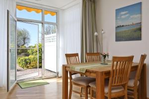 a dining room with a table and chairs and a window at Am Seeufer 59b Fewo 3 in Waren +9 photos