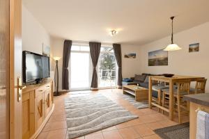 a living room with a television and a dining room at Haus am Kölpinsee App 3 3 in Waren