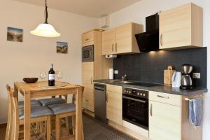 a kitchen with a small table and a kitchen with a stove at Haus am Kölpinsee App 3 3 in Waren