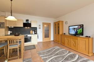 a kitchen with a table and a tv on a counter at Haus am Kölpinsee App 3 3 in Waren