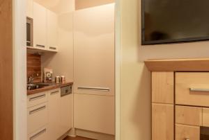 a kitchen with white cabinets and a sink at Hafendomicil Appartement WH05 - Maus in Waren
