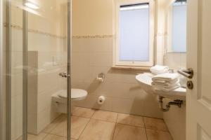 a bathroom with a toilet and a sink and a shower at Hafendomicil Appartement WH05 - Maus in Waren