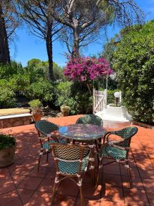 a table and chairs on a patio with pink flowers at Villa Pineta - Holiday House in Anacapri
