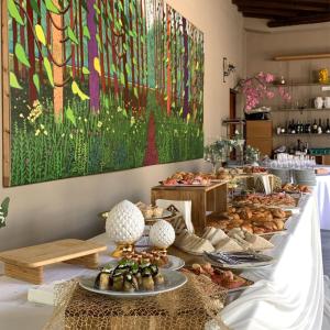 a buffet line with plates of food and a painting at VillaGrancassa Hotel Relais in San Donato Val di Comino +82 photos