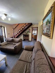a living room with a couch and a staircase at Gestiona2R - Casa Dos Carmenes, caminando a la playa, ideal familias in Llanes