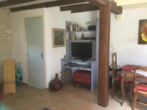 a living room with a television on a desk at Les Mialles in Prayssac