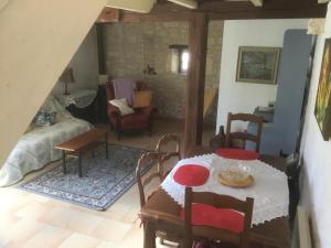 a living room with a table and a room with a couch at Les Mialles in Prayssac +23 photos