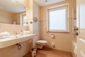 a bathroom with a sink and a toilet and a window at Hafendomicil Appartement WH06 - Hase in Waren