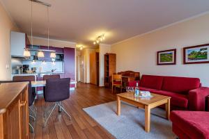 a living room with a red couch and a table at Hafendomicil Appartement WH07 - Fuchs in Waren
