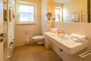 a bathroom with a sink and a toilet and a mirror at Hafendomicil Appartement WH11 - Eichhörnchen in Waren