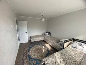 a room with two twin beds and a rug at Амир гостевой дом в Корумду in Korumdy