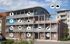 a building with clocks on the side of it at Hafendomicil Appartement WH13 - Eisvogel in Waren
