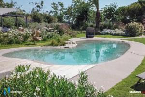 a small swimming pool in a yard with a patio at Villa Pietrarosa by MMega in Cascina Monte Serico