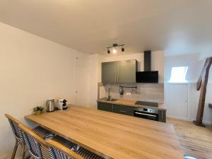 a kitchen with a wooden table and a counter top at Hyper Centre Beauvais Cosy Appartement in Beauvais
