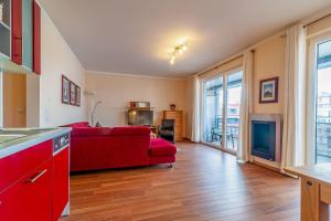 a living room with a red couch and a kitchen at Hafendomicil Appartement WH15 - Adler in Waren