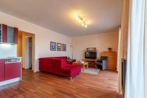 a living room with a red couch and a kitchen at Hafendomicil Appartement WH15 - Adler in Waren