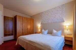 a bedroom with a large white bed and wooden cabinets at Hafendomicil Appartement WH15 - Adler in Waren +5 photos