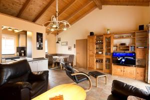 a living room with leather furniture and a dining room at Ferienhaus Jabel 28 in Jabel