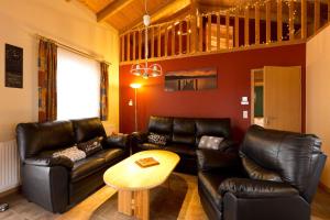 a living room with leather couches and a table at Ferienhaus Jabel 28 in Jabel +18 photos