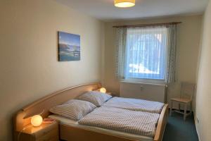 a bed in a bedroom with a window at UG-Birke in Göhren-Lebbin