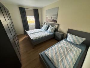 a small bedroom with two beds and a couch at UG-Buche in Göhren-Lebbin