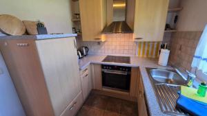 a small kitchen with a sink and a stove at Ferienhaus Jabel 30 in Jabel