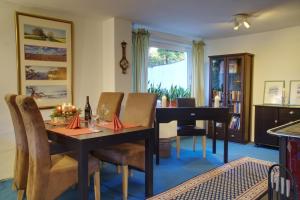 a dining room with a table and a piano at Gästehaus Wildblume in Borgdorf-Seedorf