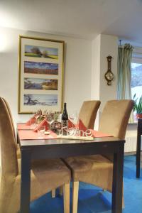 a dining room table with chairs and wine glasses on it at Gästehaus Wildblume in Borgdorf-Seedorf +10 photos