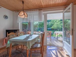 a dining room with a table and chairs and sliding glass doors at Groot Huus in Lärz