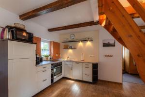 a kitchen with white cabinets and a wooden floor at Ferienhaus Loppin in Jabel
