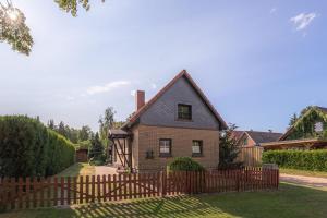 a house with a wooden fence in the yard at Ferienhaus Loppin in Jabel