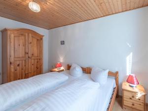 a bedroom with a large white bed with two lamps at Luett Huus in Lärz