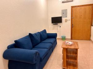 a living room with a blue couch and a table at الكرامة للشقق المفروشة in Abha