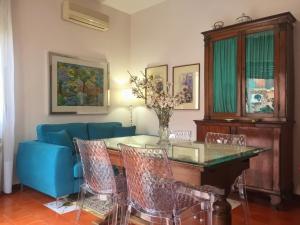 a living room with a table and a blue couch at Holiday Home Alessia n 3 ,Centro Storico di Taormina in Taormina
