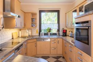 a large kitchen with wooden cabinets and a window at Die Jagdhütte in Dedelow