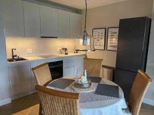 a kitchen with a table and chairs and a kitchen with a refrigerator at Seeresidenz Klink in Klink