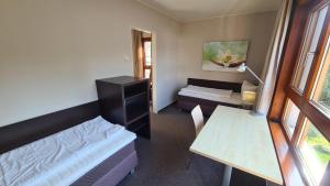 a small room with a bed and a desk and a window at Seeresidenz Klink in Klink +3 photos