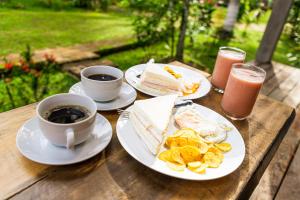 a wooden table with plates of food and cups of coffee at Retazos Eco Hotel in Iquitos
