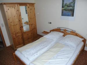 a bedroom with a bed and a wooden cabinet at Tannenblick Loppin EG in Jabel