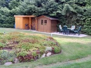 a shed with a table and chairs in a yard at Tannenblick Loppin EG in Jabel