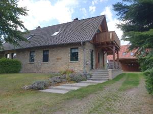 a large brick house with a wooden roof at Tannenblick Loppin EG in Jabel +1 photo