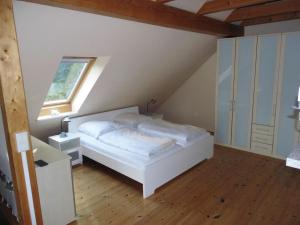 a bedroom with a white bed and a window at Tannenblick Loppin DG in Jabel