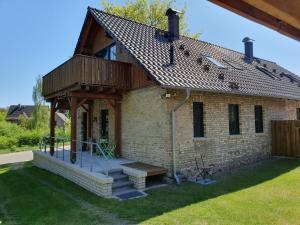 a brick house with a porch and a wooden roof at Tannenblick Loppin DG in Jabel +1 photo